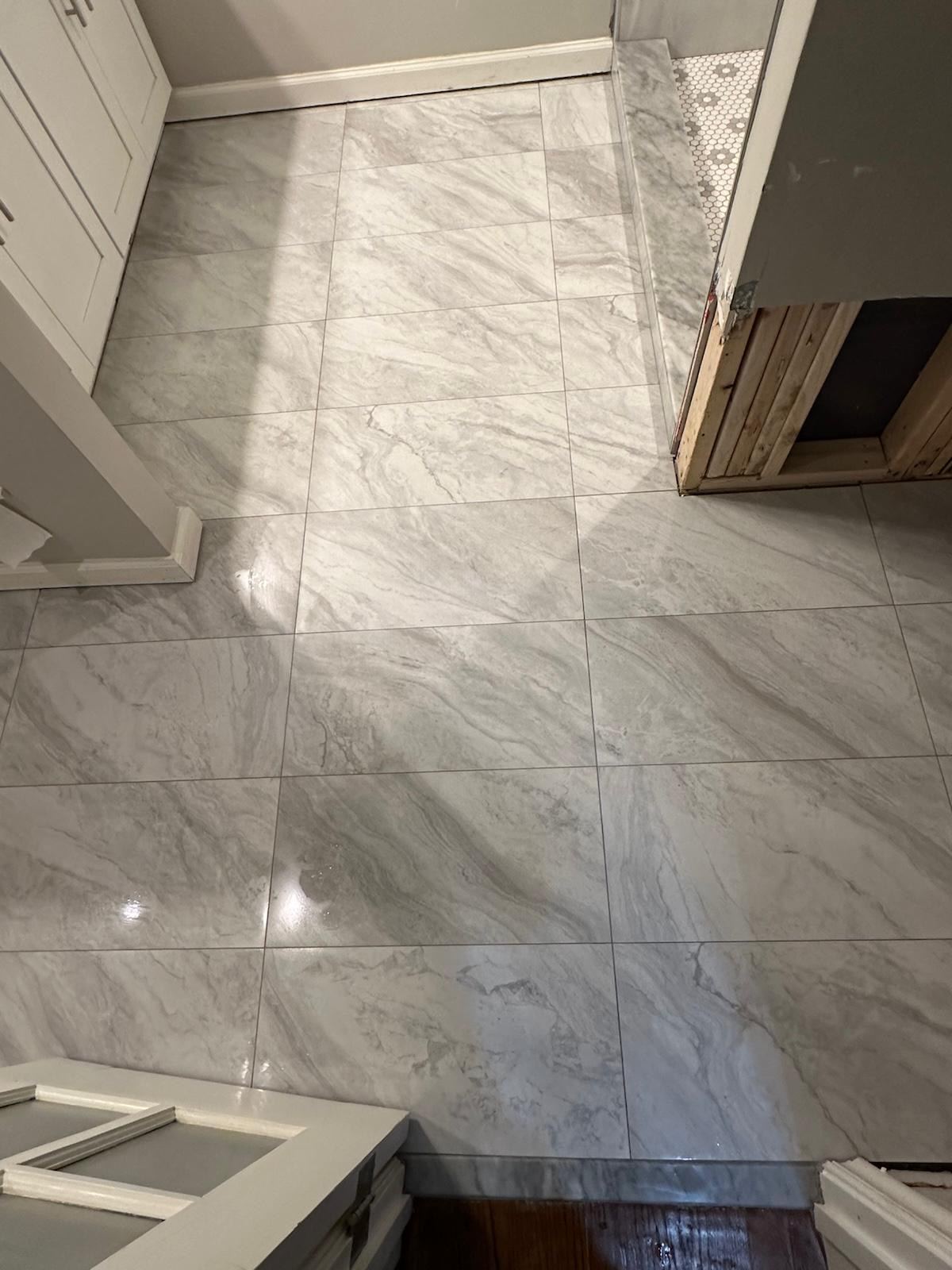 Large-format marble-look porcelain floor tile in a wide room