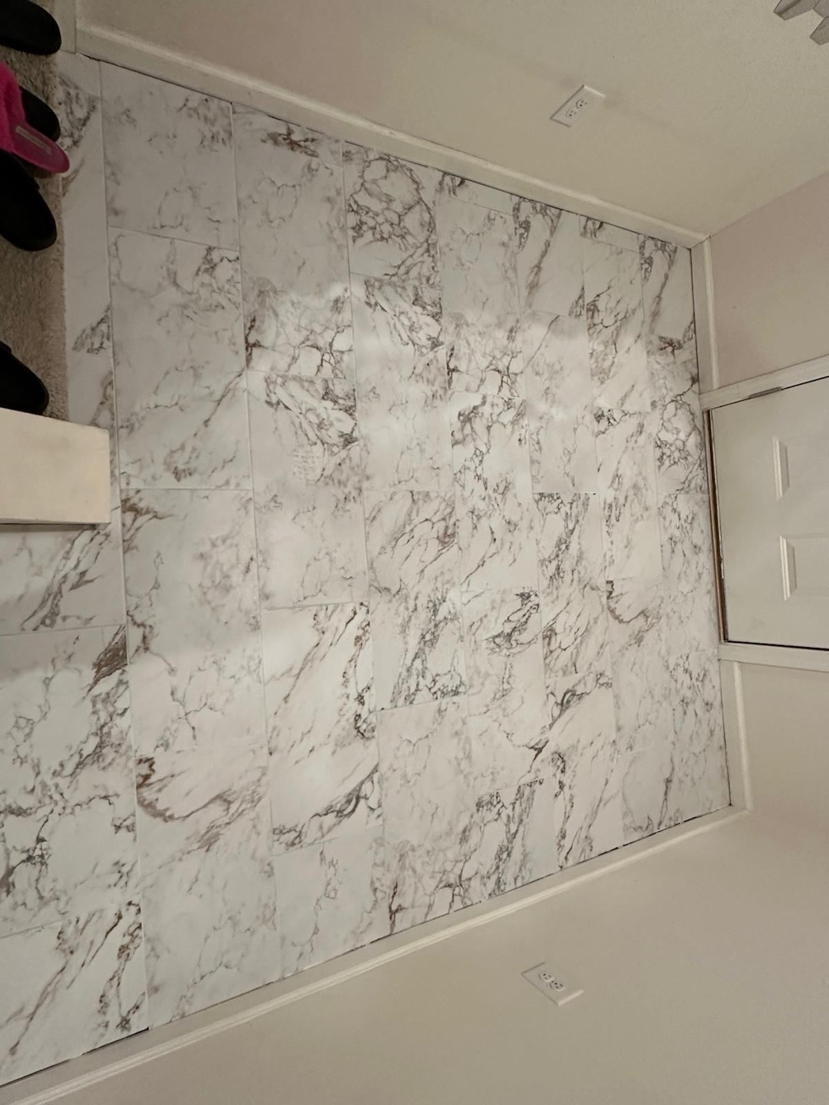 Marble-look tile accent wall next to a closet