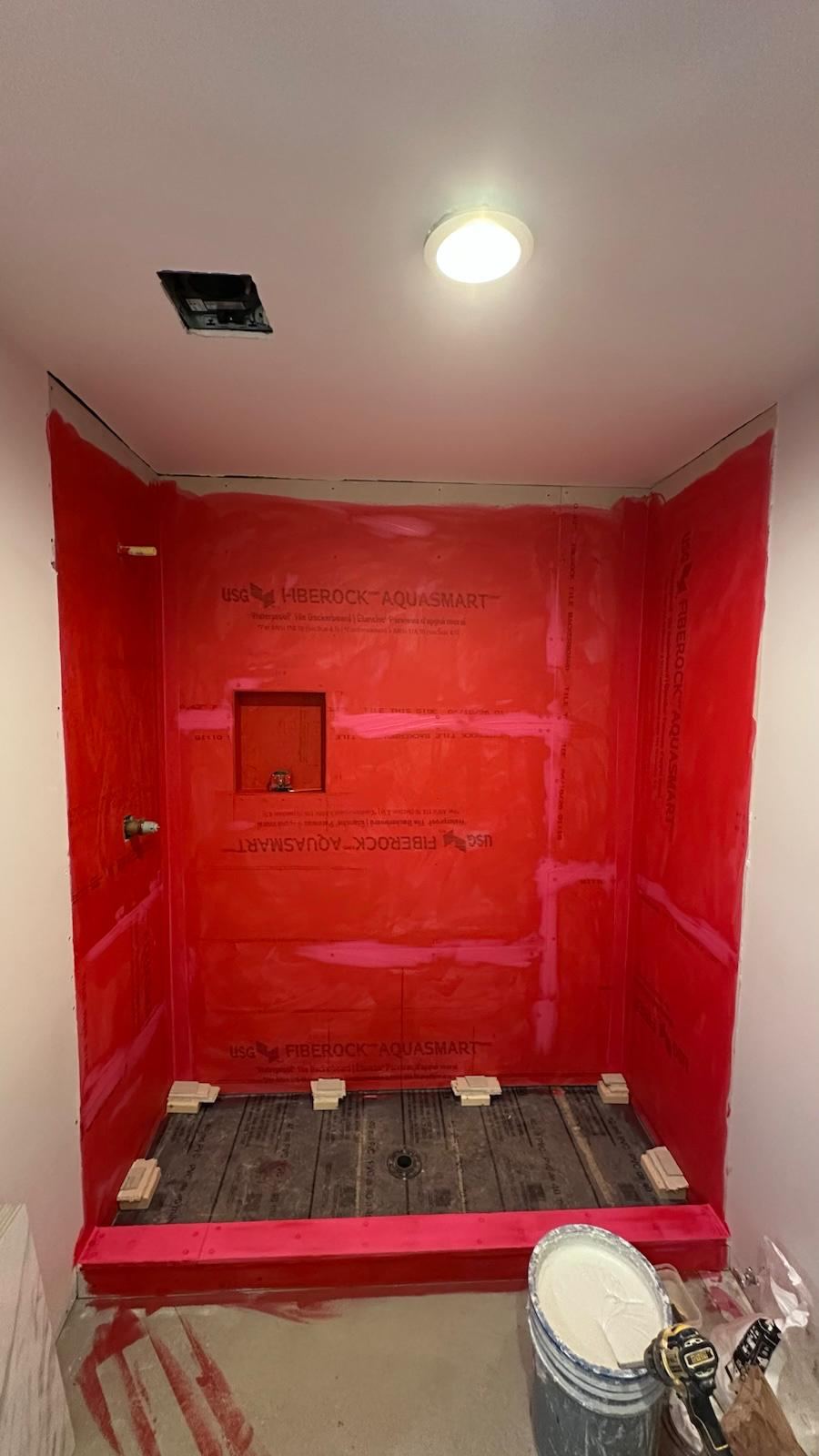 Shower being prepped with waterproofing membrane before tile installation